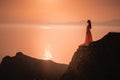 woman in long dress standing on a rock and looking to a sea Royalty Free Stock Photo