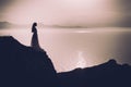 woman in long dress standing on a rock and looking to a sea Royalty Free Stock Photo