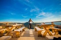 Young woman with long hair have rest in open air cafe on top of mountains and enjoy view