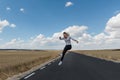 Young woman jumping on the road on nowhere Royalty Free Stock Photo