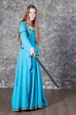 Young woman with long hair poses with sword Royalty Free Stock Photo