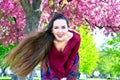 Young woman with long hair smiling on camera in front of Sakura Royalty Free Stock Photo