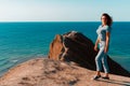 A young woman with long hair stands on the slope of Cape chameleon with an amazing panoramic view of the hills and the sea from ab Royalty Free Stock Photo