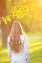 Young woman with long hair turned back outdoors in sun light Wa