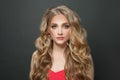 Young woman with long healthy curly blonde hair on black background Royalty Free Stock Photo