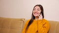 Young woman with long loose hair talks on smartphone at home