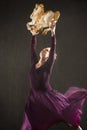 Young woman in purple dress dancing with antique carousel horse. Royalty Free Stock Photo