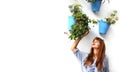 Young woman with long red hair in tradicional street frigiliana andalucia spain smelling flowers in blue pots on white