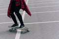 Young woman with longboard on asphalt does a trick on a city street