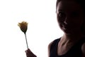 Young woman look ahead with flower - horizontal silhouette of a side view Royalty Free Stock Photo