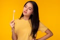 Young woman look at toothbrush, get unsatisfied and unhappy Attractive beautiful girl canÃ¢â¬â¢t choose good quality of toothbrush