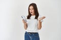 Young woman looking angry and confused at smartphone screen, complaining on broken app, standing disappointed over white