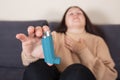 Young woman looking for an asthma inhaler during strong asthma attack, cannot breathing, healthcare concept
