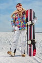 Young woman looking away while holding snowboard in snow Royalty Free Stock Photo