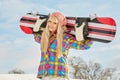 Young woman looking away while holding snowboard in snow Royalty Free Stock Photo