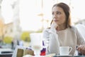 Young woman looking away while sitting at sidewalk cafe Royalty Free Stock Photo