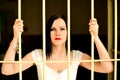Young woman looking from behind the bars Royalty Free Stock Photo