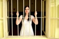 Young woman looking from behind the bars Royalty Free Stock Photo