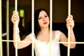 Young woman looking from behind the bars Royalty Free Stock Photo