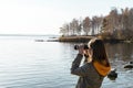 Young woman looking through binoculars at birds on lake Birdwatching, zoology, ecology. Research in nature, observation of animals Royalty Free Stock Photo