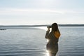 Young woman looking through binoculars at birds on lake Birdwatching, zoology, ecology. Research in nature, observation of animals Royalty Free Stock Photo