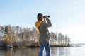 Young woman looking through binoculars at birds on lake Birdwatching, zoology, ecology. Research in nature, observation of animals Royalty Free Stock Photo