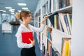 Young woman looking book at the shelf in library Royalty Free Stock Photo