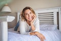 Portrait of happy woman lying on bed and looking at camera Royalty Free Stock Photo