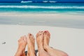 Young woman looking down of view perspective on bare feet standing in white sand Royalty Free Stock Photo