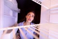 Young woman looking at empty shelves of her refrigerator Royalty Free Stock Photo
