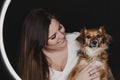 Young woman looking at er cute dog. black background. studio shot. love for animals concept Royalty Free Stock Photo