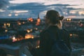 Young woman looking at evening city from skyscraper viewing plat Royalty Free Stock Photo
