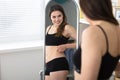 Reflection Of Woman Pinches Fat On Her Belly Royalty Free Stock Photo