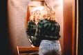 Young woman looking at herself in the mirror while standing in hallway at home Royalty Free Stock Photo