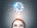 Young woman looking at light bulb on blackboard Royalty Free Stock Photo