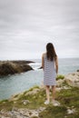 Young woman looking at a lonely and beautiful rocky coast