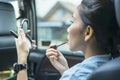 Young woman applying lipstick on her lips in car Royalty Free Stock Photo