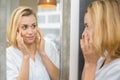 young woman looking in mirror and putting make-up on Royalty Free Stock Photo