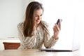 Young woman looking at mobile phone and computer Royalty Free Stock Photo