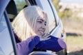 Young woman looking out of a car window during a road trip