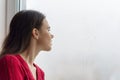 Young woman looking out the window on a rainy day, copy space Royalty Free Stock Photo