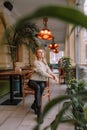 Young woman looking out the window while sitting in a chair on a winter day Royalty Free Stock Photo