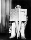 Young woman looking over top of an oversized book