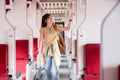 Young woman looking for a place to store her luggage in the train Vacation holiday, tourism, travel, interior of modern Royalty Free Stock Photo