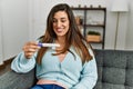 Young woman looking pregnancy test result sitting on sofa at home Royalty Free Stock Photo