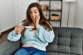 Young woman looking pregnancy test result sitting on sofa at home Royalty Free Stock Photo