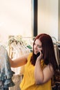 young woman looking at price tags of clothes to buy, in a fashion shop. shopping concept. talking on mobile phone. Royalty Free Stock Photo