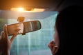 Young woman looking in rear view mirror and putting make up. Royalty Free Stock Photo