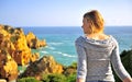 Young woman looking at sea cliffs, Lagos Royalty Free Stock Photo