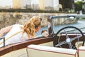 Woman looking into side view mirror of classic retro car. Royalty Free Stock Photo